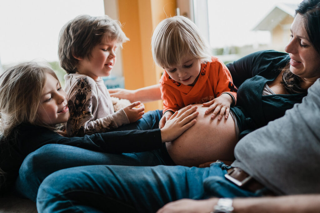 Kinder fassen alle den Babybauch an