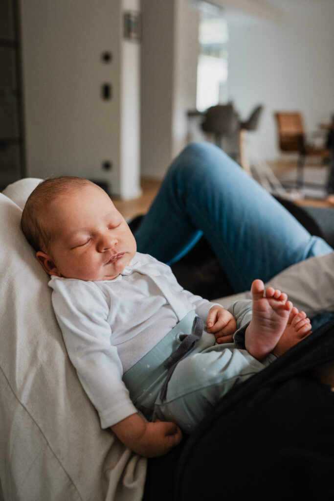 Baby liegt auf Schoß von Eltern