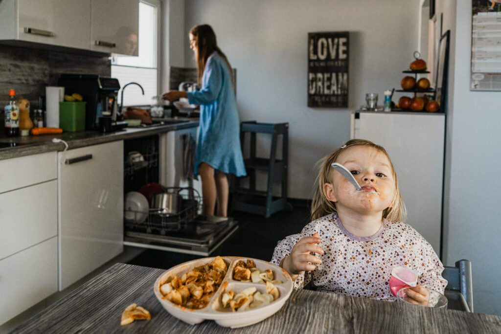 Familienshooting Mama und Tochter isst im Vordergrund